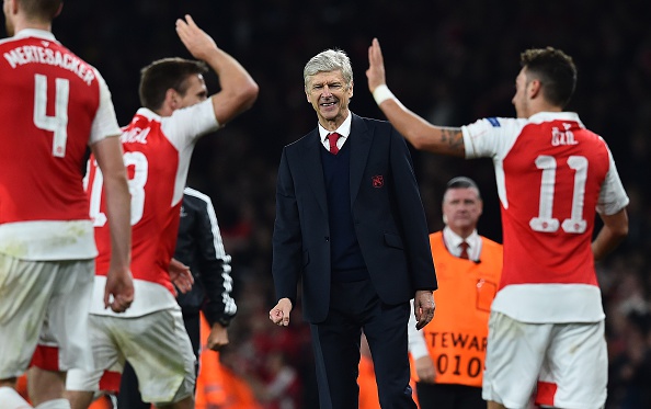 Arsenal's French manager Arsene Wenger (C) watches as Arsenal's German midfielder Mesut Ozil (R) celebrates scoring his team's second goal with teamamte Arsenal's Spanish defender Nacho Monreal during the UEFA Champions League football match between Arsenal and Bayern Munich at the Emirates Stadium in London, on October 20, 2015. Arsenal won the match 2-0. AFP PHOTO / BEN STANSALL (Photo credit should read BEN STANSALL/AFP/Getty Images)